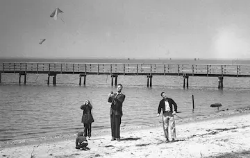 Rogallo with his children flying his wing on a beach.